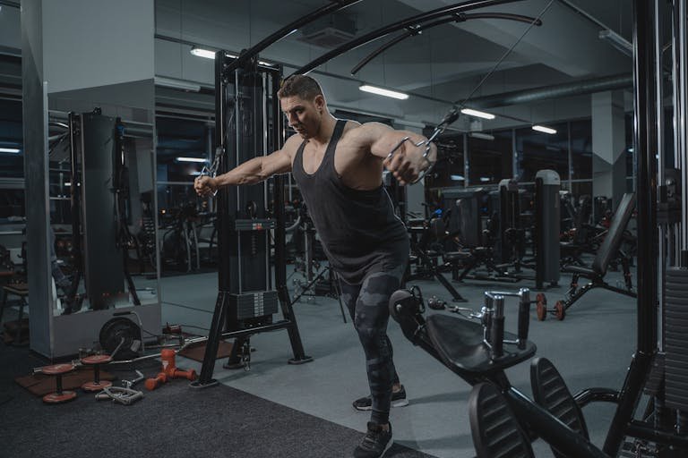 A Man Using the Cable Crossover Machine at the Gym