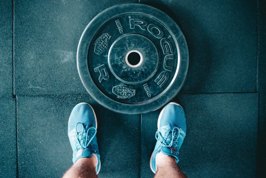 Black Steel Gym Plate and Pair of Blue Running Shoes