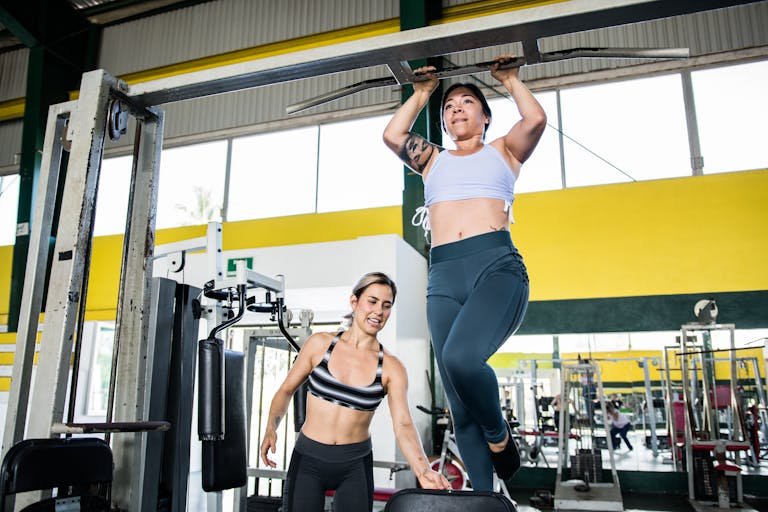 Woman Practicing Pull-Ups at Gym